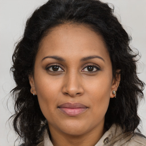 Joyful black young-adult female with long  brown hair and brown eyes