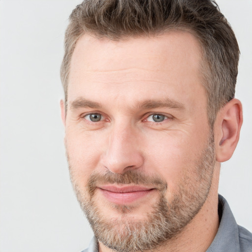 Joyful white adult male with short  brown hair and grey eyes