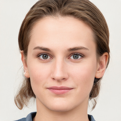 Joyful white young-adult female with medium  brown hair and blue eyes