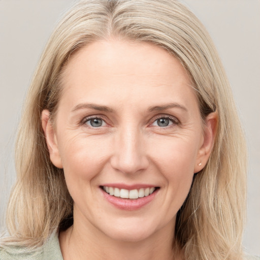 Joyful white adult female with medium  brown hair and blue eyes