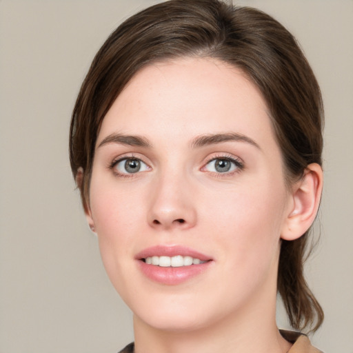 Joyful white young-adult female with medium  brown hair and green eyes