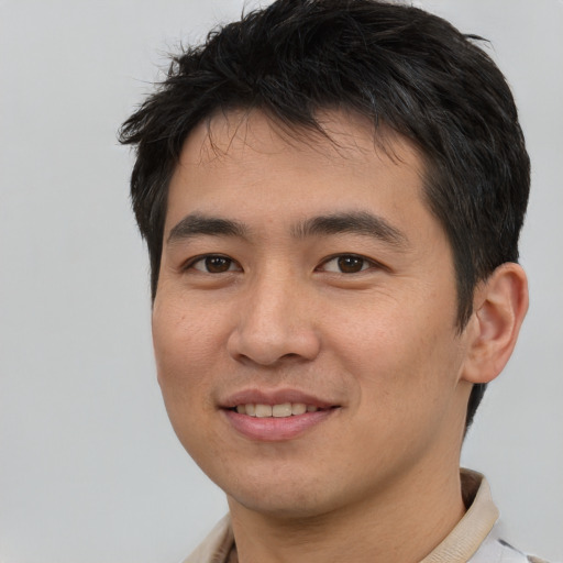 Joyful asian young-adult male with short  brown hair and brown eyes