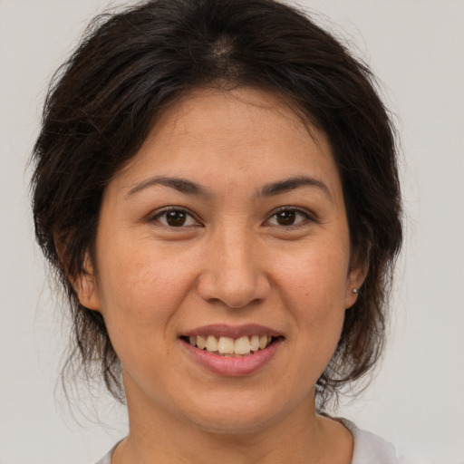 Joyful latino adult female with medium  brown hair and brown eyes
