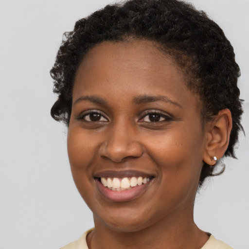 Joyful black young-adult female with short  brown hair and brown eyes