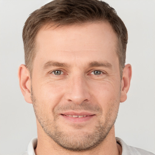 Joyful white adult male with short  brown hair and grey eyes