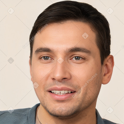 Joyful white young-adult male with short  brown hair and brown eyes