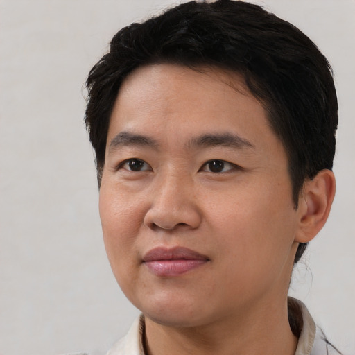 Joyful asian young-adult male with short  brown hair and brown eyes