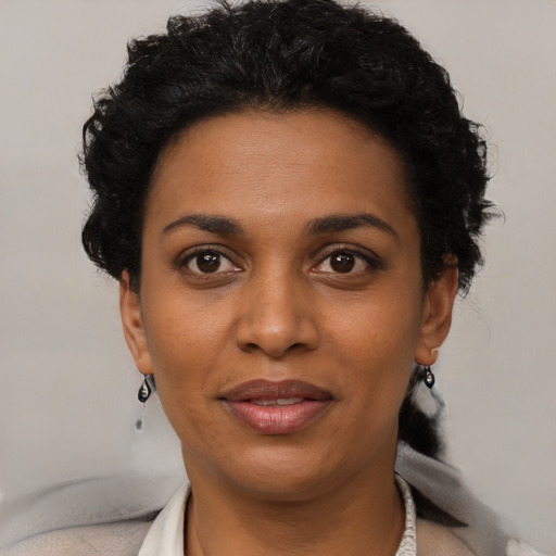 Joyful black young-adult female with short  black hair and brown eyes