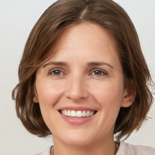 Joyful white adult female with medium  brown hair and grey eyes