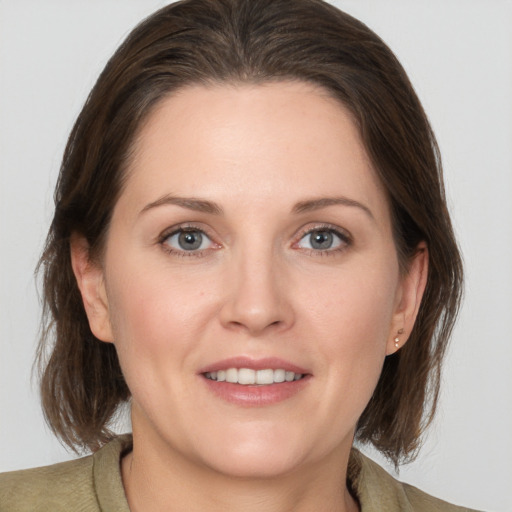 Joyful white adult female with medium  brown hair and grey eyes