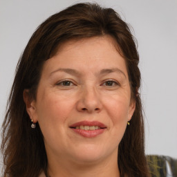 Joyful white adult female with long  brown hair and brown eyes