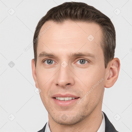 Joyful white young-adult male with short  brown hair and grey eyes