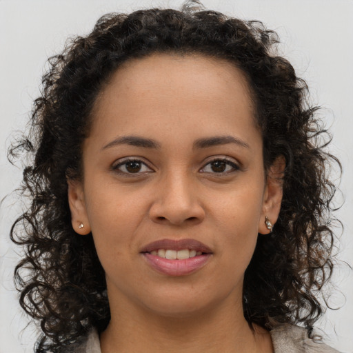 Joyful black young-adult female with long  brown hair and brown eyes
