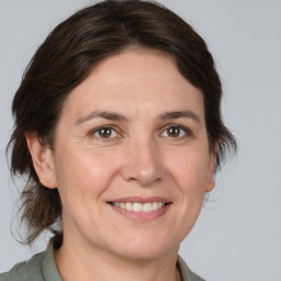 Joyful white adult female with medium  brown hair and brown eyes