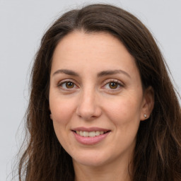 Joyful white adult female with long  brown hair and brown eyes