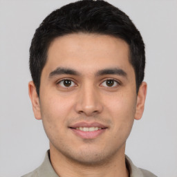 Joyful latino young-adult male with short  brown hair and brown eyes