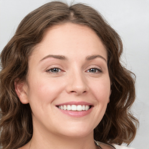 Joyful white young-adult female with long  brown hair and green eyes