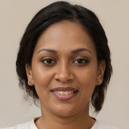 Joyful black adult female with medium  brown hair and brown eyes
