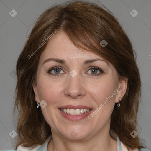 Joyful white adult female with medium  brown hair and blue eyes