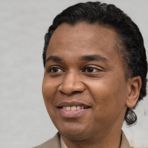 Joyful black adult male with short  black hair and brown eyes