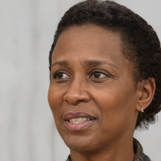 Joyful black adult female with short  brown hair and brown eyes