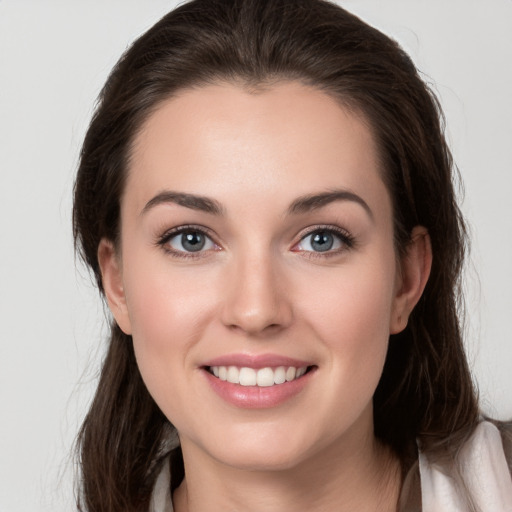 Joyful white young-adult female with medium  brown hair and grey eyes