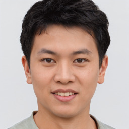 Joyful asian young-adult male with short  brown hair and brown eyes