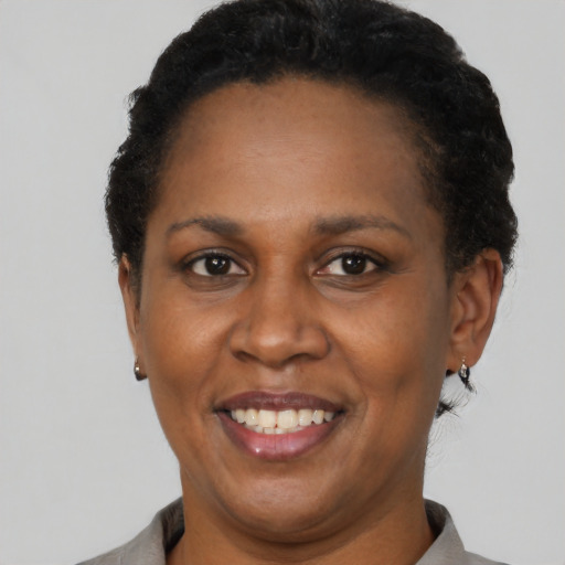 Joyful black adult female with short  black hair and brown eyes