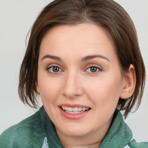 Joyful white young-adult female with medium  brown hair and green eyes