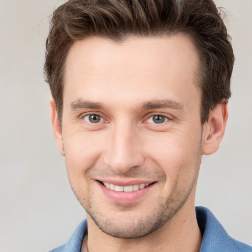 Joyful white young-adult male with short  brown hair and grey eyes