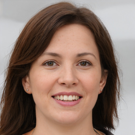 Joyful white young-adult female with long  brown hair and brown eyes