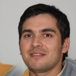 Joyful white young-adult male with short  black hair and brown eyes