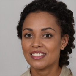 Joyful black young-adult female with long  brown hair and brown eyes