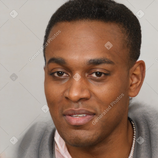 Joyful black young-adult male with short  black hair and brown eyes