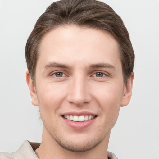 Joyful white young-adult male with short  brown hair and grey eyes