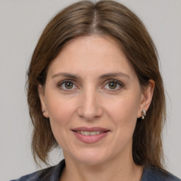 Joyful white adult female with medium  brown hair and grey eyes