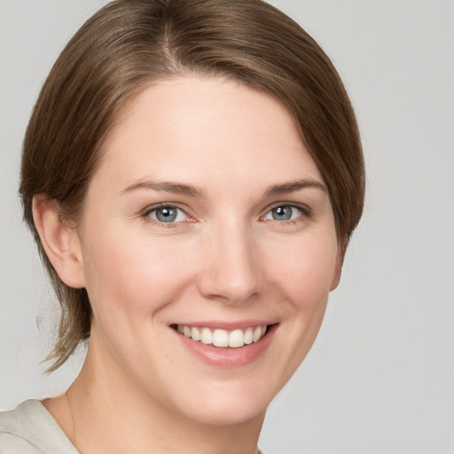 Joyful white young-adult female with medium  brown hair and grey eyes