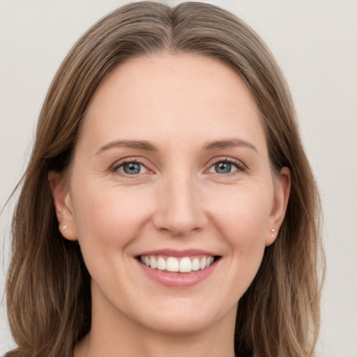 Joyful white young-adult female with long  brown hair and grey eyes