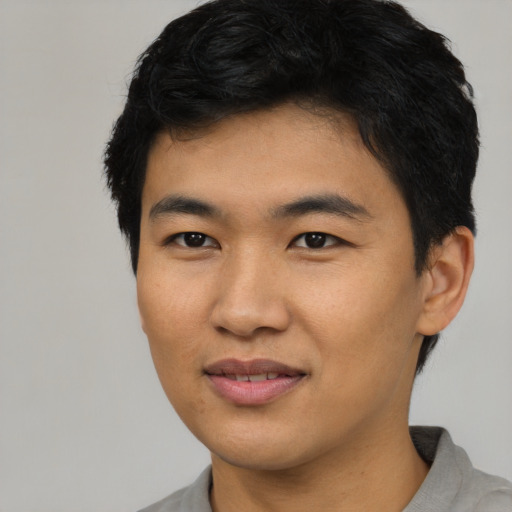 Joyful asian young-adult male with short  black hair and brown eyes
