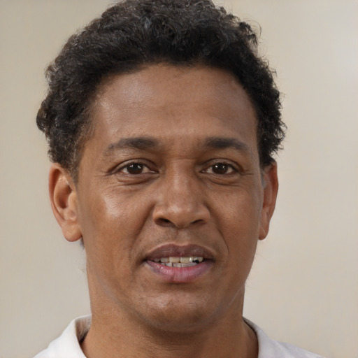 Joyful black young-adult male with short  brown hair and brown eyes