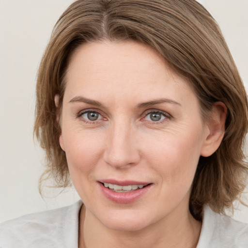 Joyful white young-adult female with medium  brown hair and blue eyes