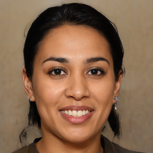 Joyful latino young-adult female with medium  brown hair and brown eyes