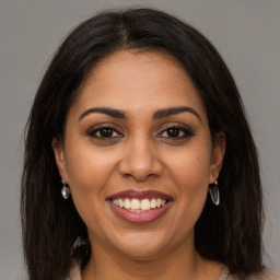 Joyful latino young-adult female with long  brown hair and brown eyes