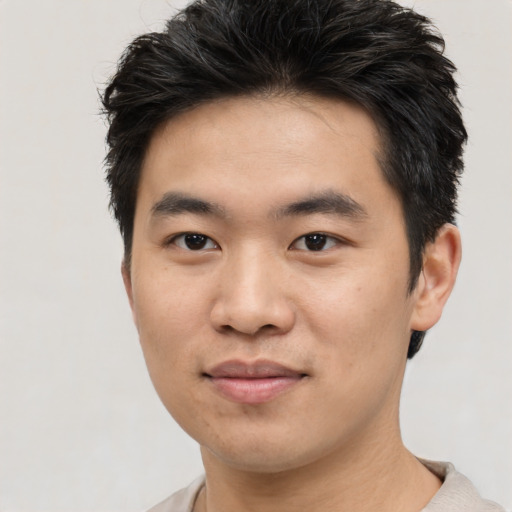 Joyful asian young-adult male with short  brown hair and brown eyes