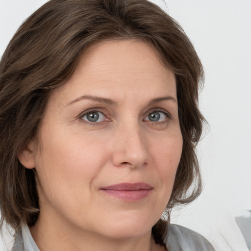 Joyful white adult female with medium  brown hair and grey eyes