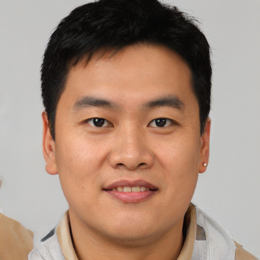 Joyful asian young-adult male with short  brown hair and brown eyes