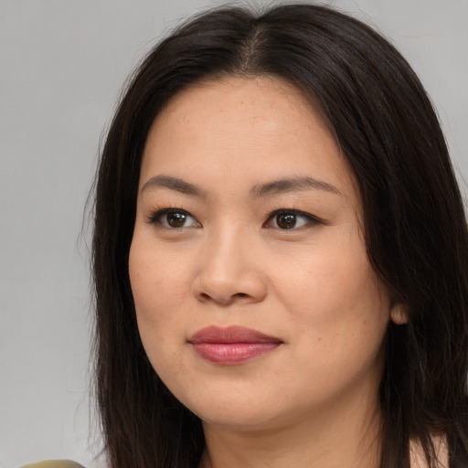 Joyful asian young-adult female with long  brown hair and brown eyes