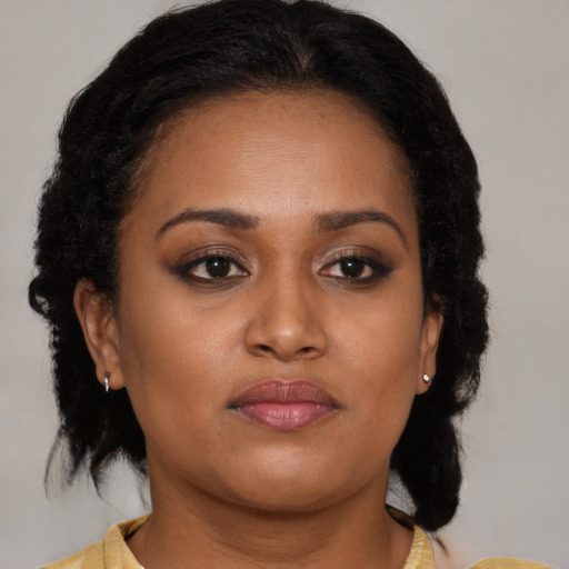 Joyful black young-adult female with medium  brown hair and brown eyes