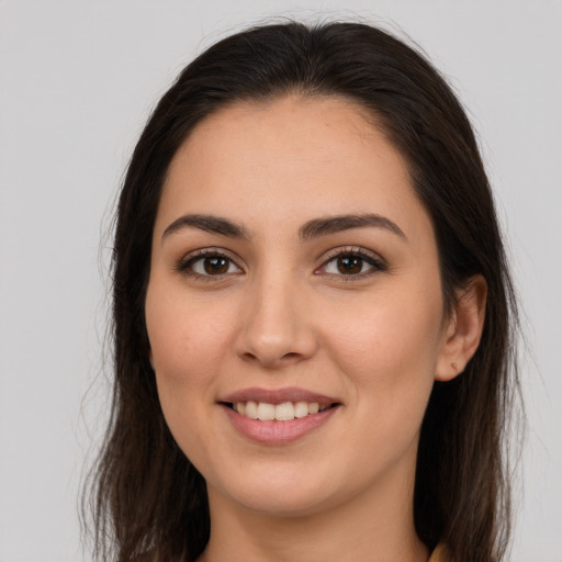 Joyful white young-adult female with long  brown hair and brown eyes