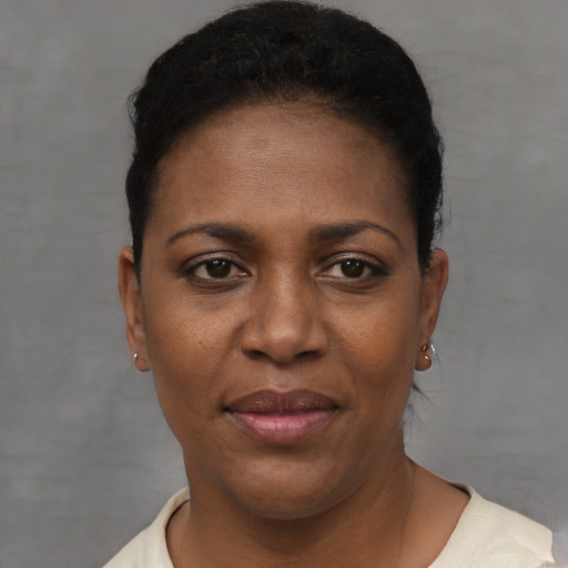 Joyful black young-adult female with short  black hair and brown eyes